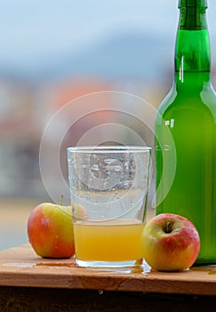 Pouring in glass of natural Asturian cider made fromÂ fermented apples, Asturian cabrales cow blue cheese with view on Covadonga